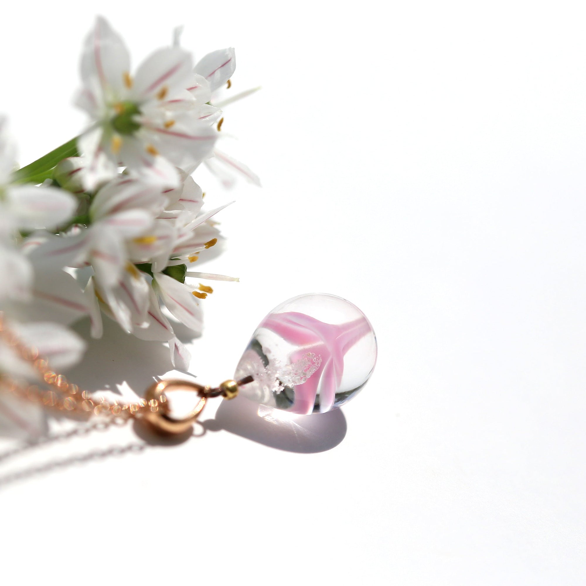 不透明ピンク色のお花が入った ガラスの遺骨ペンダント