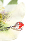 不透明赤色のお花が入った ガラスの遺骨ペンダント