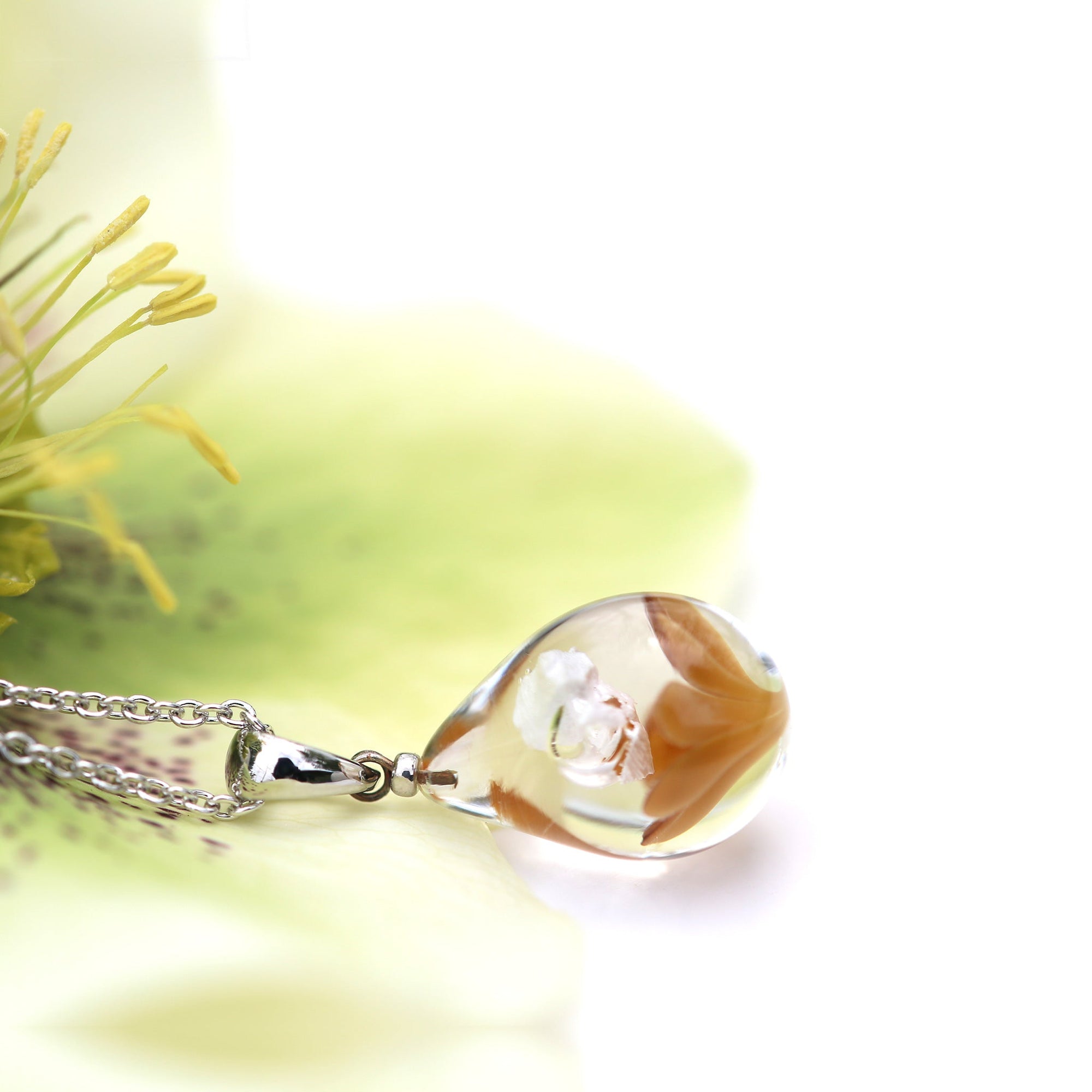 不透明薄茶色のお花が入った ガラスの遺骨ペンダント