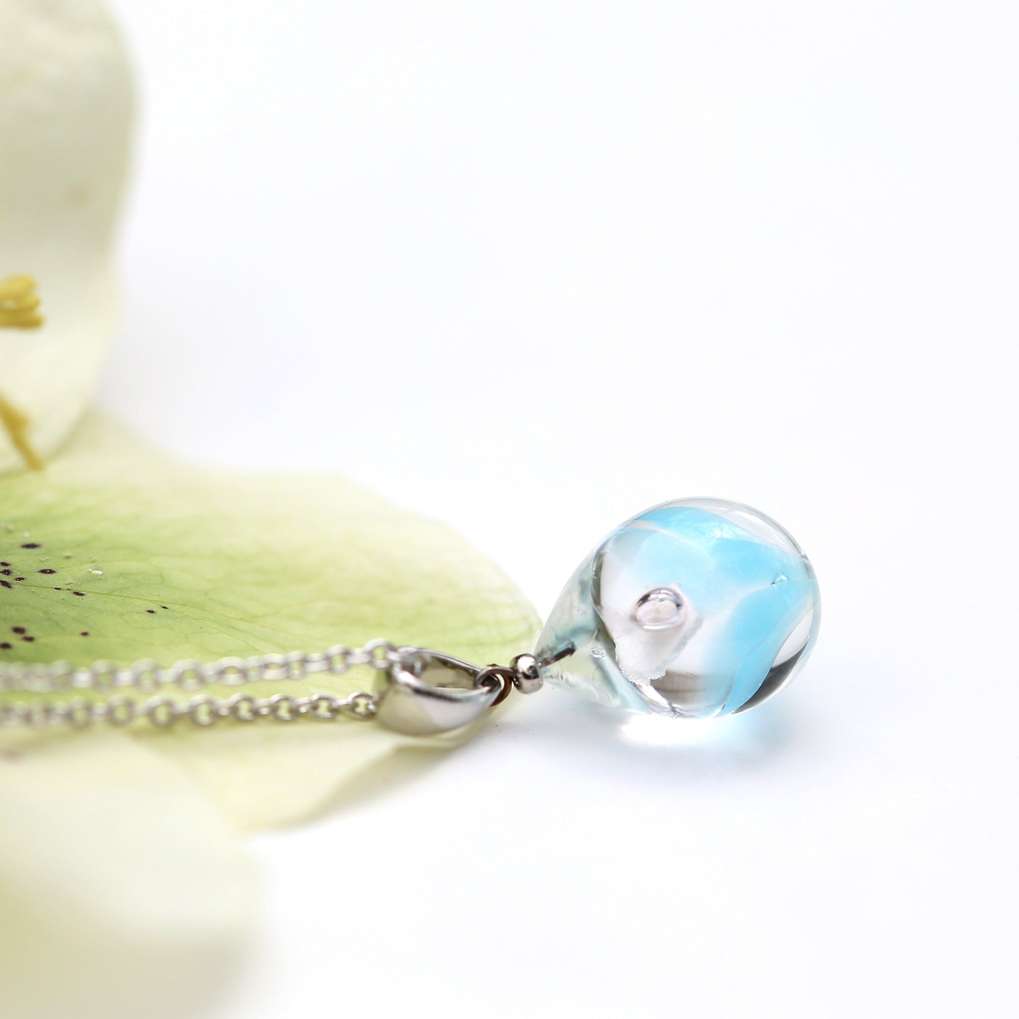 半透明水色のお花が入った ガラスの遺骨ペンダント