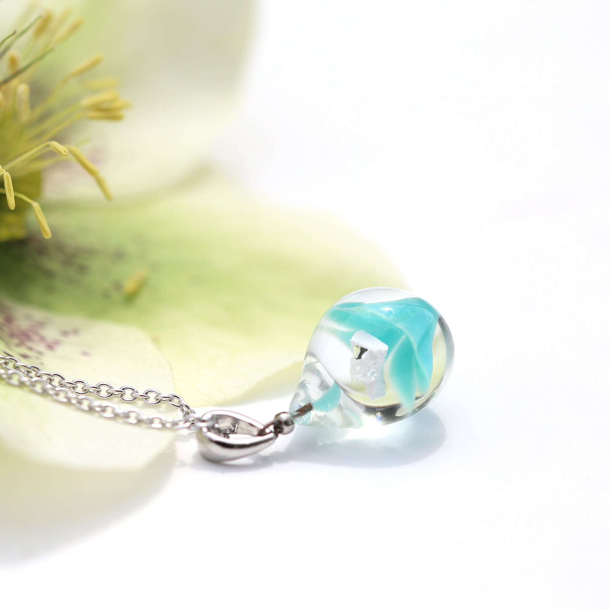 不透明薄青緑色のお花が入った ガラスの遺骨ペンダント