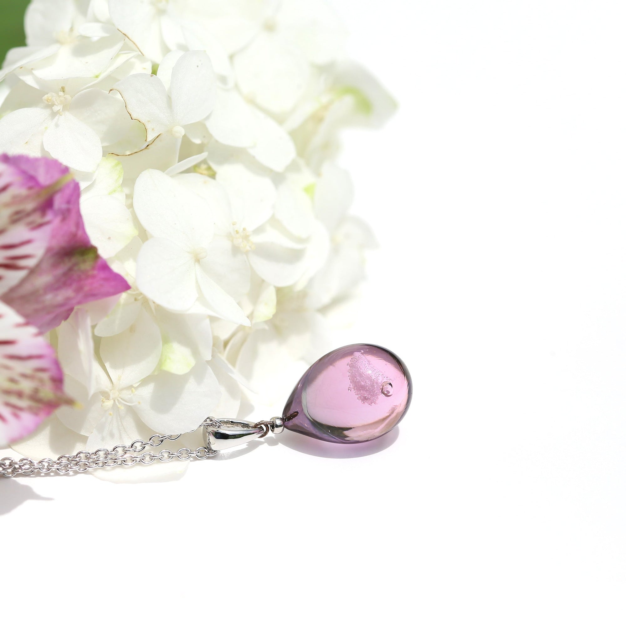 薄グレー薄ピンク色のグラデーションが美しい ガラスの遺骨ペンダント