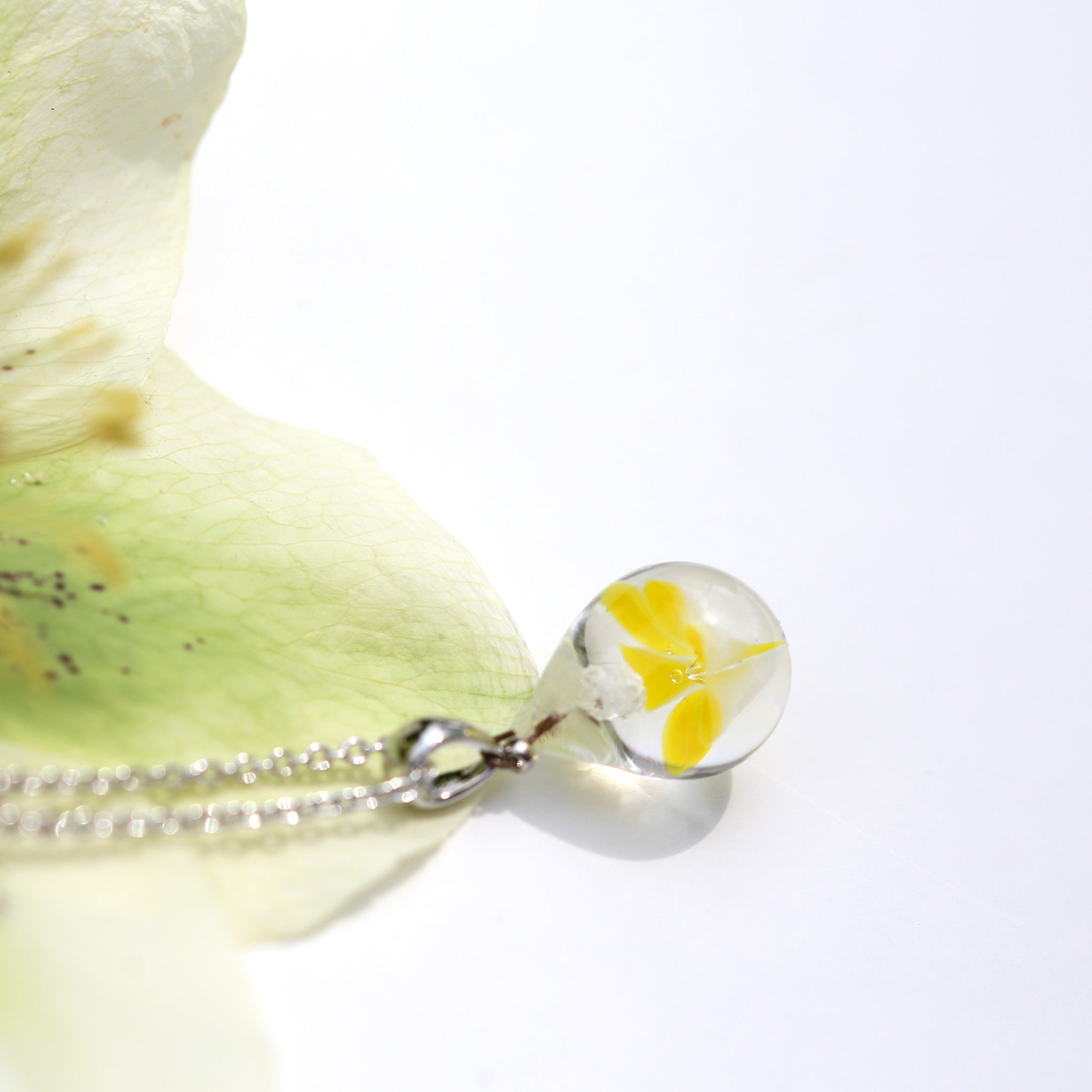 黄色半透明白色のお花が入った　ガラスの遺骨ペンダント